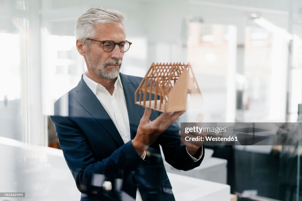 Businessman examining architectural model in office
