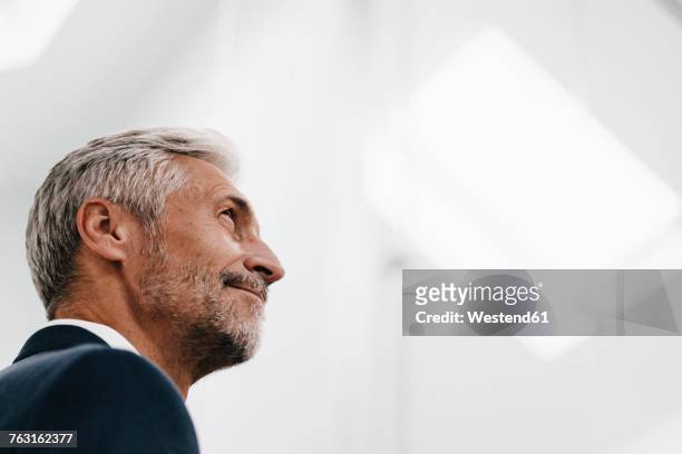confident mature businessman looking up - man looking up photos et images de collection