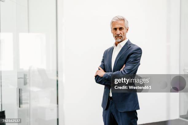 portrait of serious mature businessman in office - dreiviertelansicht stock-fotos und bilder