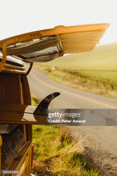 yellow surfboard in vintage recreational vehicle boot on roadside, exeter, california, usa - boots stock pictures, royalty-free photos & images