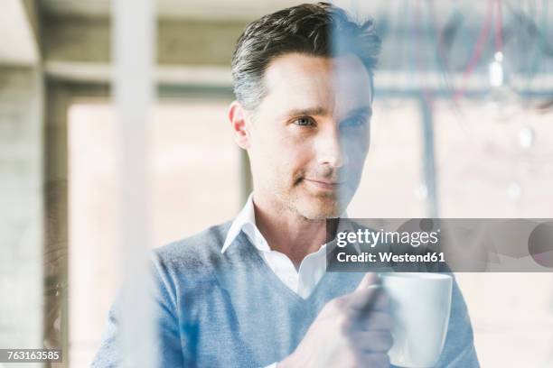 businessman looking at transparant projection screen in office - café homme vitre photos et images de collection