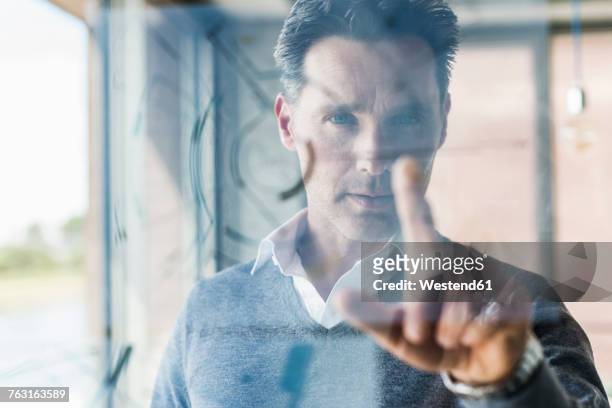 businessman touching transparant projection screen in office - touching stock pictures, royalty-free photos & images
