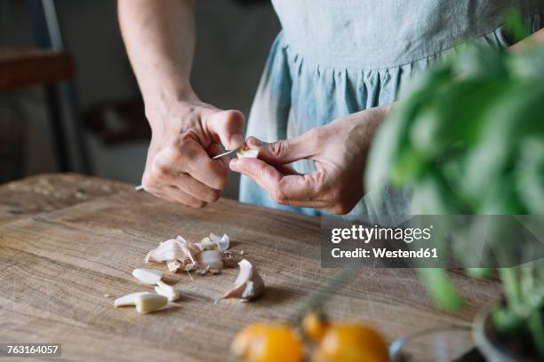 close-up of woman peeling garlic - woman look up stockfoto's en -beelden