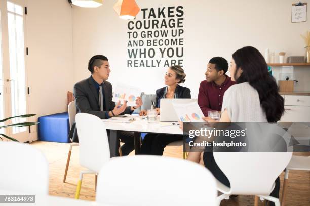 young businessman explaining at team meeting - heshphoto stock pictures, royalty-free photos & images