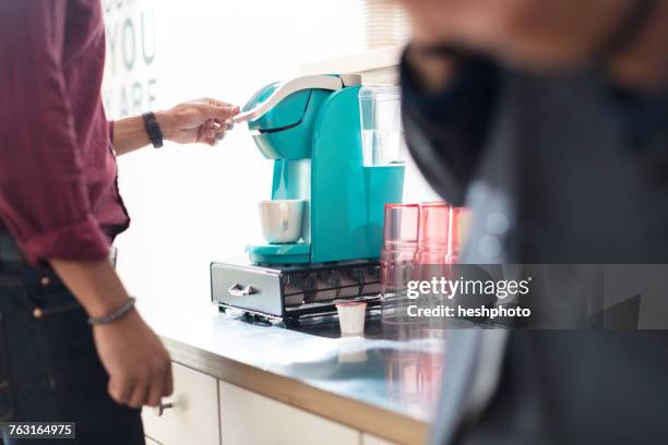 cropped shot of businessman using coffee machine - heshphoto stock pictures, royalty-free photos & images