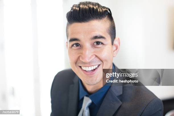 portrait of smiling young businessman in office - heshphoto stock pictures, royalty-free photos & images