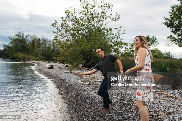 couple skimming stones on beach, oshawa, canada - oshawa 個照片及圖片檔