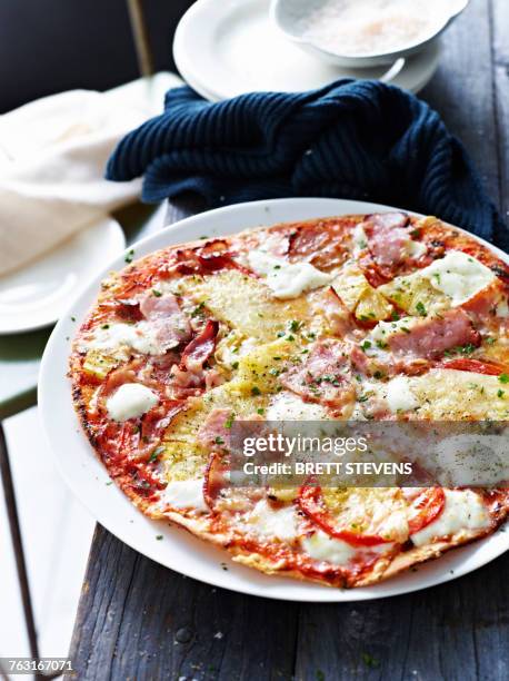 ham and pineapple pizza on white plate, close-up - hawaiian pizza stock pictures, royalty-free photos & images