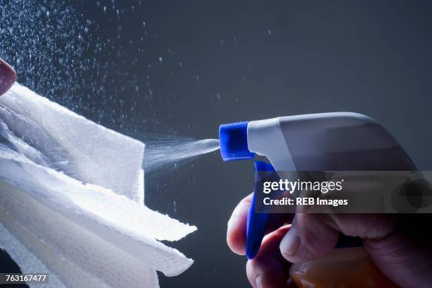 cropped view of man spraying cleaning product of cloth - spray cleaner stock pictures, royalty-free photos & images