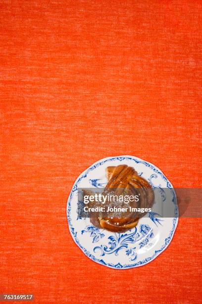 a bun on a plate - cinnamon bun stock pictures, royalty-free photos & images