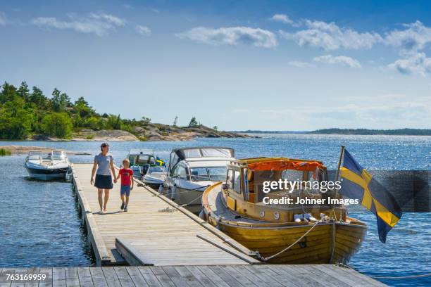 mother with son walking on jetty - smaland stock-fotos und bilder