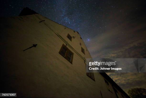 low angle view of building and starry sky - peace palace stock-fotos und bilder