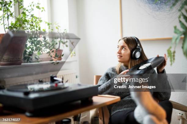 woman with headphones listening to records - vinylplaat stockfoto's en -beelden