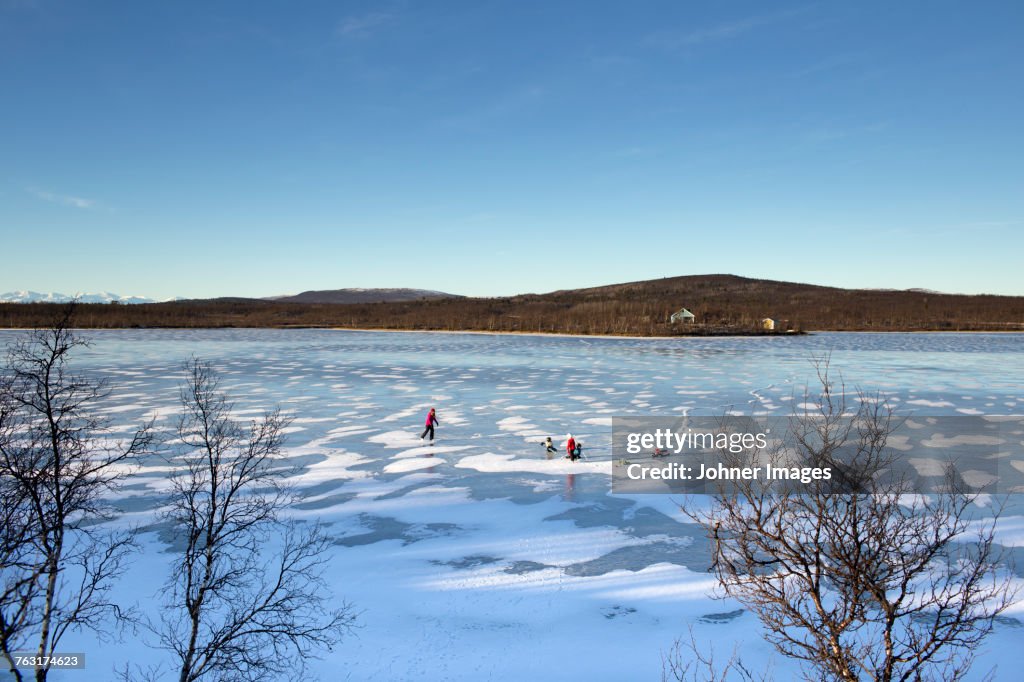 People skating on frozen lake