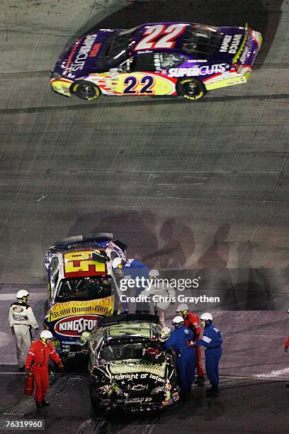 Officials and safty workers assit Marcos Ambrose, driver of the Kingsford/Bush's Ford, and Robert Richardson Jr., driver of the Checker's/U.S. Border...