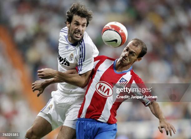 Ruud van Nistelrooy of Real Madrid duels for the ball with Mariano Pernia of Atletico de Madrid during the Spanish League match between Real Madrid...