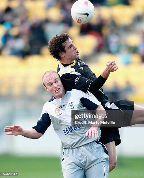 Daniel of the Phoenix heads the ball as he is challenged by Mathew Kemp of the Victory Melbourne during the round one Hyundai A-League match between...