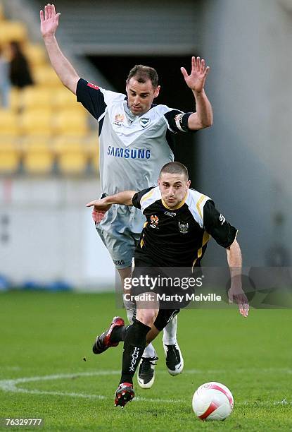 Michael Ferrante of the Phoenix contests the ball with Kevin Muscat of the Victory during the round one Hyundai A-League match between Wellington...