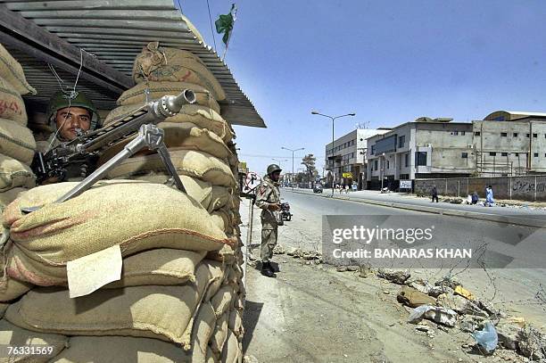 Pakistani paramilitary soldiers stand guard alongside a bunker during a strike in Quetta, 26 August 2007, on the first death anniversary of...