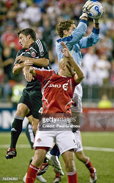 Toronto FC forward Danny Dichio goes up for the ball with DC United keeper Troy Perkins and defender Marc Burch during the match at BMO Field in...