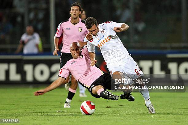 Roma forward Mirko Vucinic of Serbia is challenged by Palermo's midfielder Mark Bresciano of Australia during their Serie A football match at...