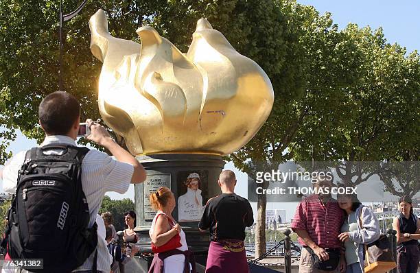 People read messages in memory of Britain's Princess Diana, 27 August 2007 at the flame of the statue of Liberty, a replica of the flame of the...