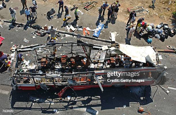 Israeli rescue workers tend to victims' bodies, lying on the pavement, at the scene of a Palestinian suicide bombing on a passenger bus in Jerusalem,...