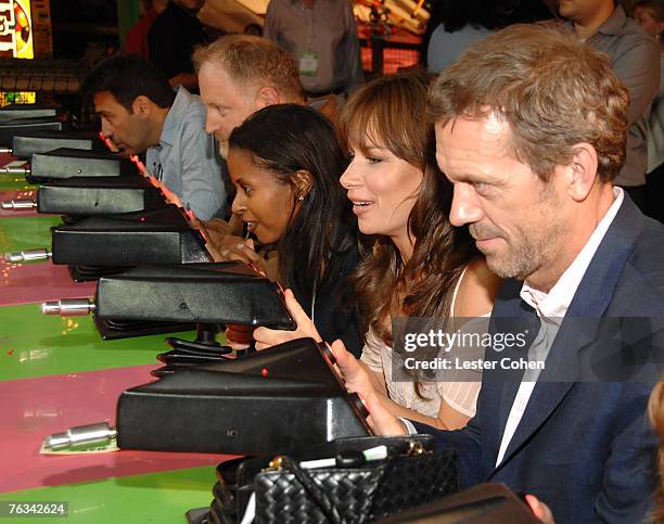 Actress Mary Lynn Rajskub and actor Hugh Laurie play a game at the FOX TCA party at Pacific Park on Santa Monica Pier in Santa Monica, California on...