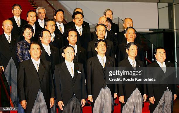 Japanese Prime Minister Shinzo Abe poses for photographers with newly-appointed members of his cabinet at the Prime Minister's official residence on...