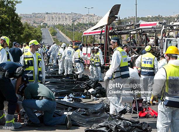 Victims' covered bodies are gathered at the scene of a Palestinian suicide bombing on a Jerusalem passenger bus June 18, 2002. At least 18 people...