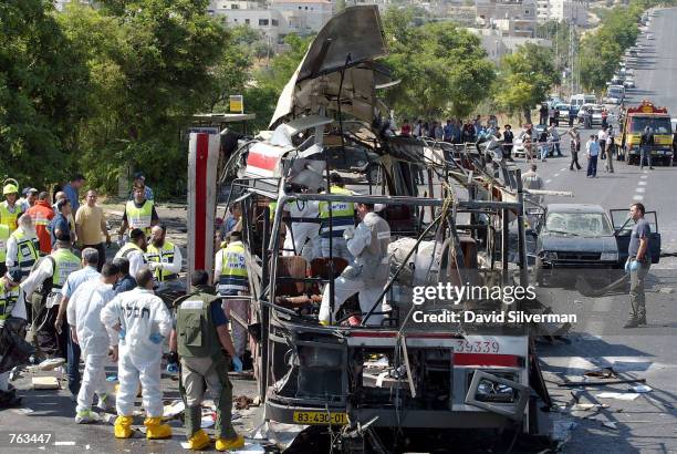 Rescue workers evacuate victims' bodies from the scene of a Palestinian suicide bombing on a Jerusalem passenger bus, June 18, 2002. At least 18...