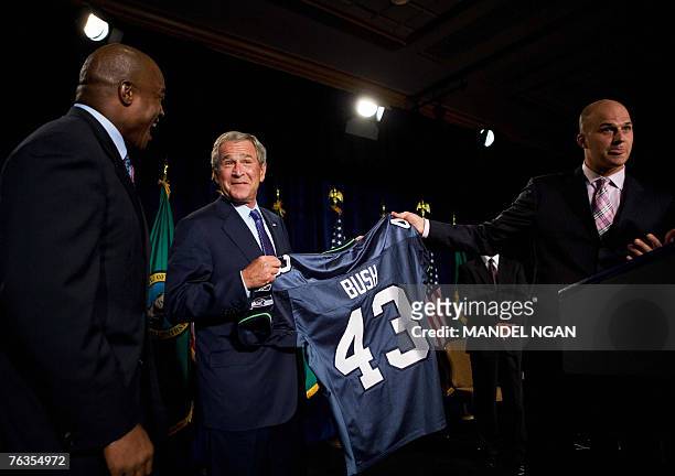 Seattle Seahawks quarterback Matt Hasselbeck and fullback Mack Strong present a jersey to US President George W. Bush during a fundraiser for...