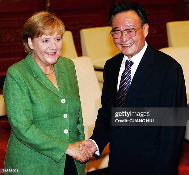 Chairman of the Standing Committee of the National People's Congress Wu Bangguo shakes hands with German Chancellor Angela Merkel at the Great Hall...