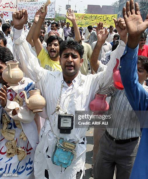 Pakistani government employees wear garlands of bread, electricity and gas meters as they shout slogans to protest against price hikes in Lahore, 28...