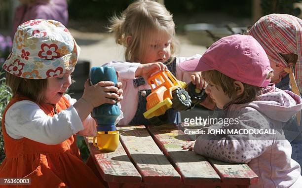German toddlers of the "Frogs" group play in the garden at the Spreekita Kindergarten in Berlin 03 May 2007. German Family Minister Ursula von der...