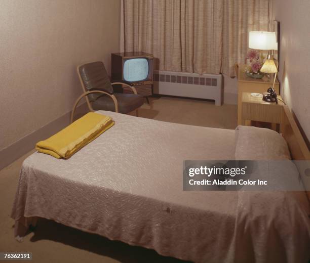 Interior view of a sparely decorated hotel room at the Thorndike Hotel, Rockland, Maine, 1960s. A television in the corner is tuned to an...
