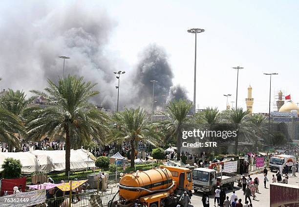 Black smoke billows as Shiite pilgrims gather in the shrine city of Karbala, 110 kms south of Baghdad, 28 August 2007. Firefights between police and...