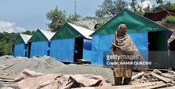 In this picture taken 16 August 2007, Pakistani Kashmiri woman Sajila Begum stands beside a five-room school made of sheets of corrugated iron, in a...