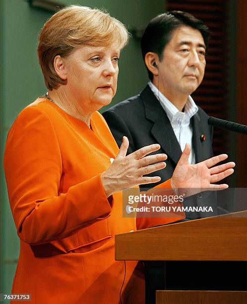 German Chancellor Angela Merkel answers a question while Japanese Prime Minister Shinzo Abe looks on during their joint press conference after their...