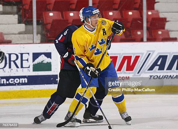 Johan Motin of Team Sweden vies for position with Ian Cole of Team USA Blue during an exhibition game on August 8, 2007 at the 1980 Rink Herb Brooks...