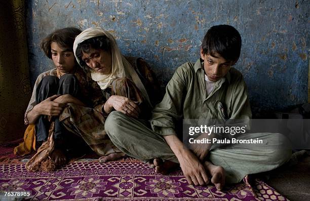 Sabera sits along side her children Zaher and Gulparai August 27, 2007 in Kabul, Afghanistan. Sabera, a widow, has been smoking for four years since...