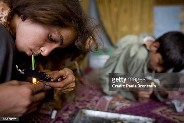 Gulparai smokes heroin along side her mother Sabera and brother Zaher August 27, 2007 in Kabul, Afghanistan. Gulparai's mother, Sabera, a widow, has...