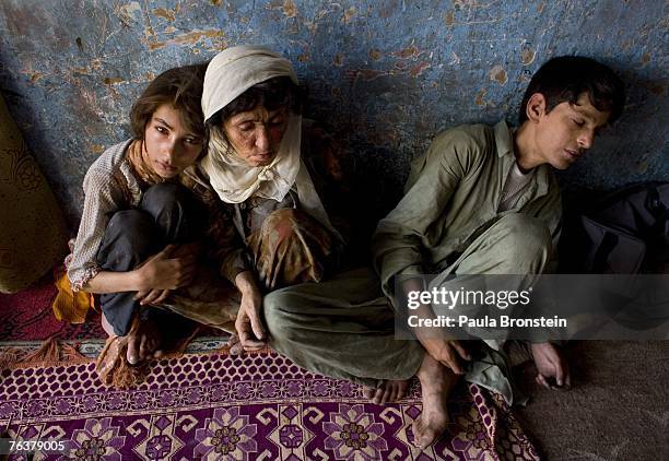 Sabera sits along side her children Zaher and Gulparai August 27, 2007 in Kabul, Afghanistan. Sabera, a widow, has been smoking for four years since...