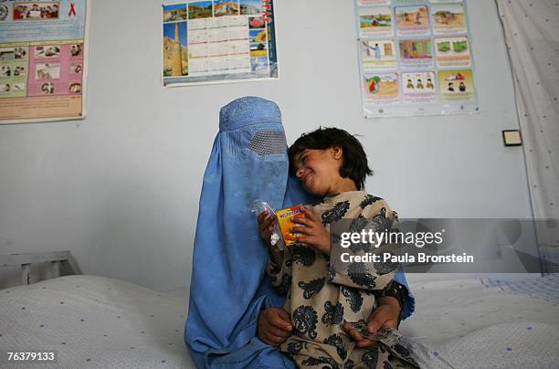 Former drug addict Habiba sits with her daughter, Farena holding medication that they received at the women's drop-in center at the New Life Center...