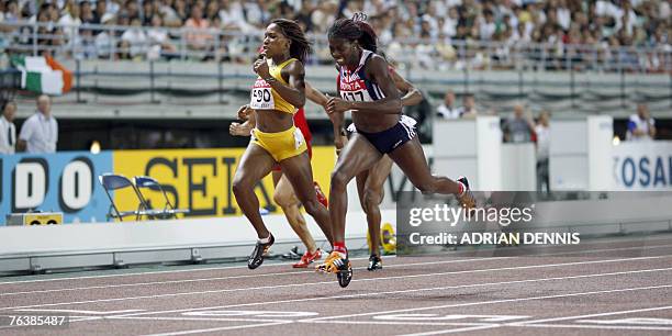 Britain's Christine Ohuruogu and Jamaica's Novlene Williams cross the finish line during the women's 400m final, 29 August 2007, at the 11th IAAF...