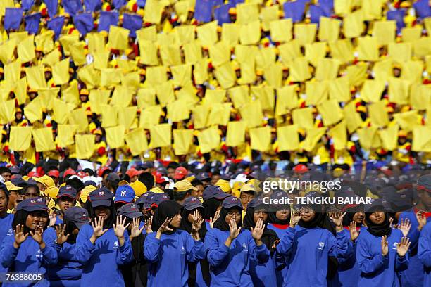 Participants in colour-coordinated groups perform during a full dress rehearsal in downtown Kuala Lumpur, 29 August 2007, for Malaysia's 50th...