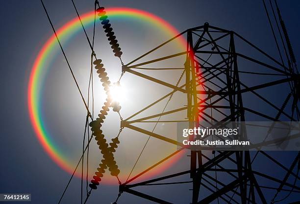 The sun shines over towers carrying electical lines August 30, 2007 in South San Francisco, California. With temperatures over 100 degrees in many...