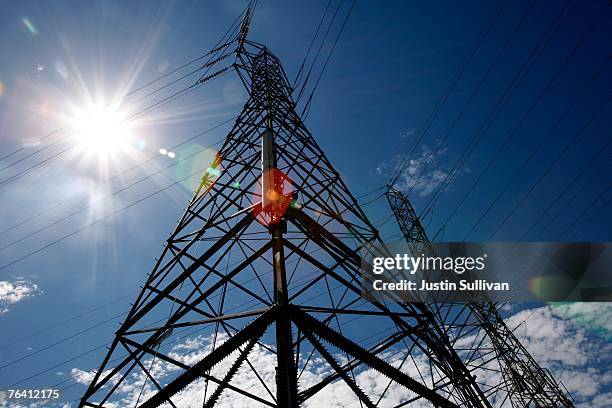 The sun shines over towers carrying electical lines August 30, 2007 in South San Francisco, California. With temperatures over 100 degrees in many...