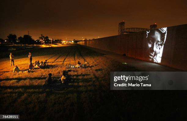 An image from the aftermath of Hurricane Katrina by Kadir von Lohuizen is projected on the Lower Ninth Ward levee wall during the "Eyes on Katrina"...