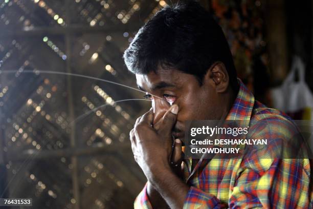 Judhisthir Rajbansi, demonstrates the skill of spraying milk from his eyelids after sucking it in through nose at his house in Agarpara, some 40 kms...